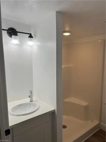 Bathroom featuring a white vanity with an undermount sink and a speckled countertop