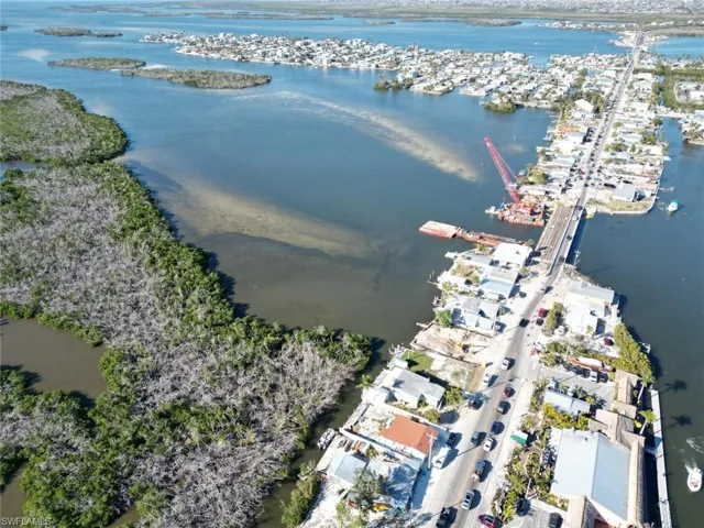 Aerial perspective showcasing waterfront properties and a thoroughfare with vehicular traffic