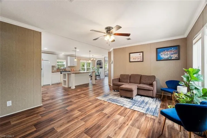 Living room featuring crown molding, ceiling fan, and hardwood / wood-style floors