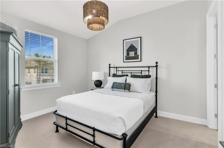 Carpeted bedroom featuring lofted ceiling