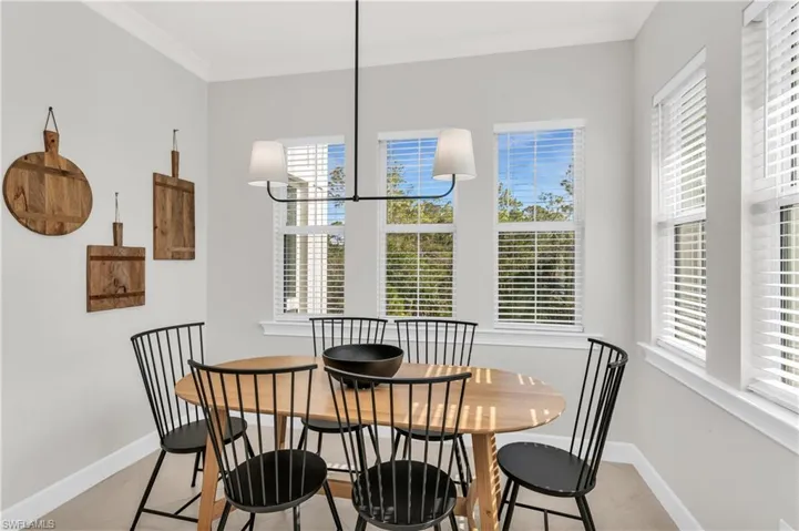 Dining space featuring a healthy amount of sunlight, ornamental molding, and a chandelier