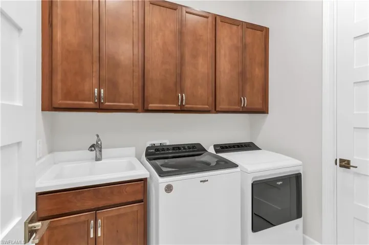 Washroom with sink, cabinets, and independent washer and dryer