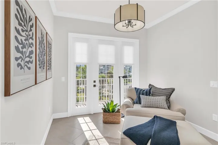 Entryway featuring light tile patterned floors and crown molding