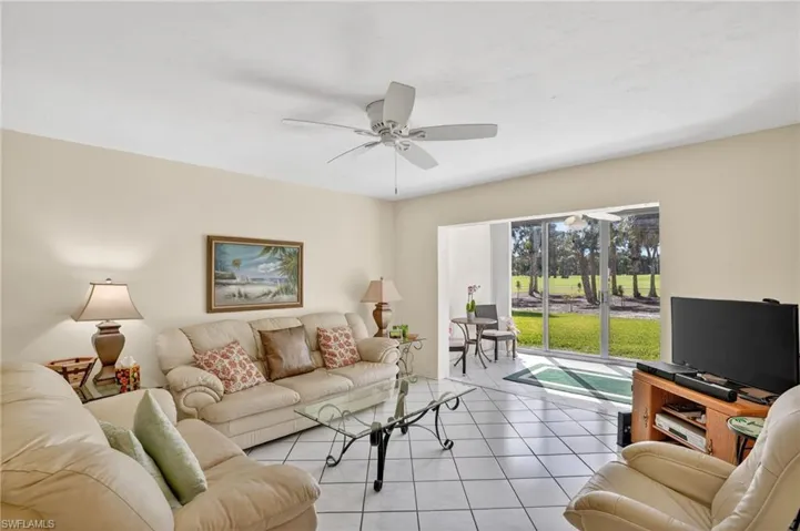 Tiled living area featuring ceiling fan