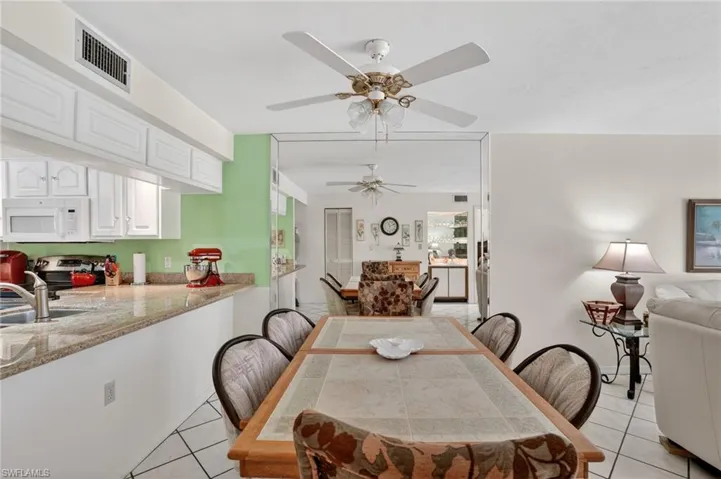 Dining space with light tile patterned floors and ceiling fan