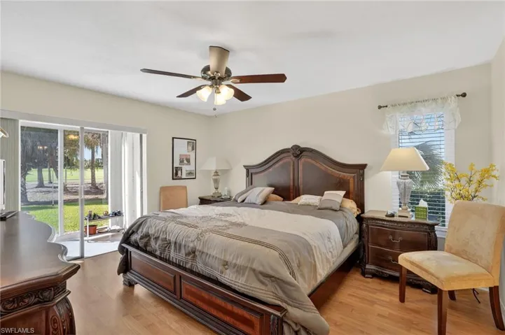 Bedroom featuring access to exterior, light wood finished floors, a ceiling fan, and multiple windows