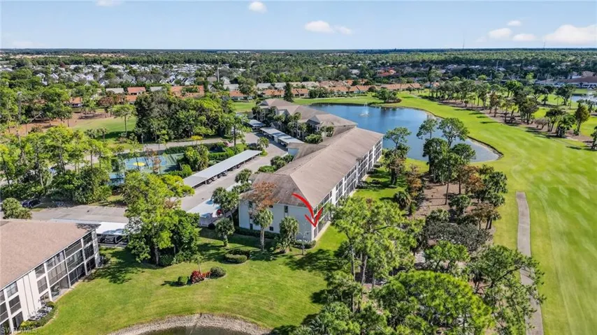 Aerial perspective of suburban area featuring a large body of water and a golf club