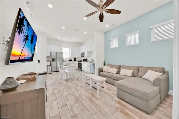 Living room featuring wood tiled floors, ceiling fan, and recessed lighting