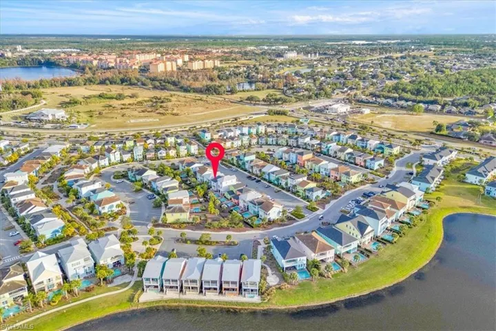 Aerial view of property's location featuring a nearby body of water and nearby suburban area