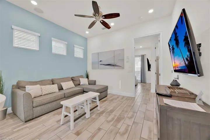 Living area featuring wood finish floors, a ceiling fan, and recessed lighting