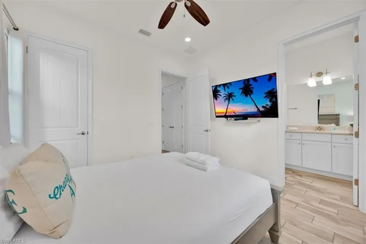 Bedroom featuring light wood-type flooring, a ceiling fan, recessed lighting, and connected bathroom