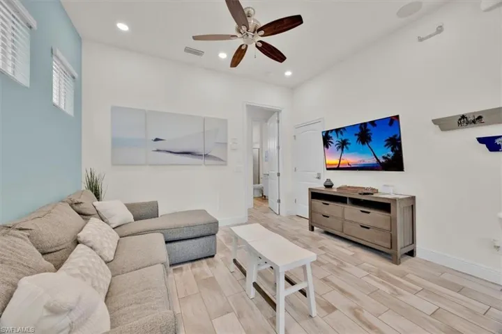 Living area with wood finish floors, ceiling fan, and recessed lighting