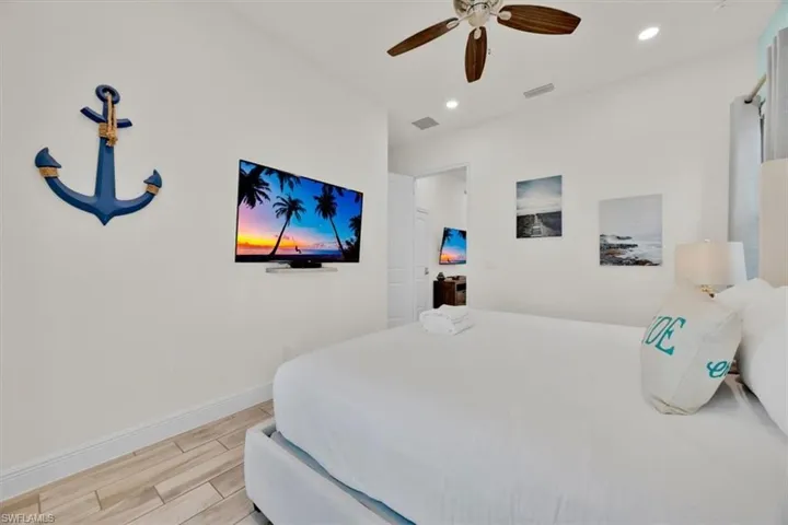 Bedroom with wood finish floors, a ceiling fan, and recessed lighting