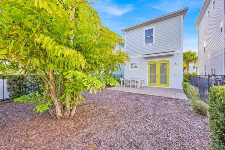 Rear view of property with a fenced backyard, a patio area, stucco siding, french doors, and outdoor dining space