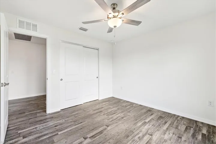 Unfurnished bedroom featuring wood-type flooring, ceiling fan, and a closet