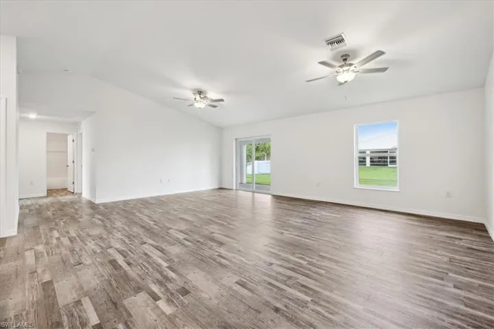 Unfurnished living room featuring lofted ceiling, ceiling fan, and hardwood / wood-style floors