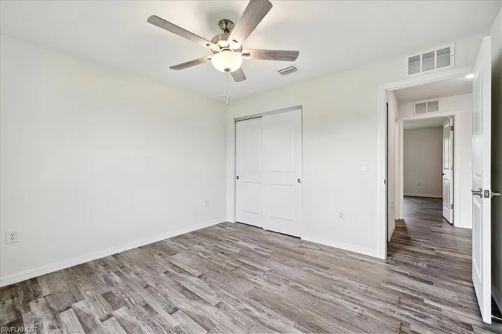 Unfurnished bedroom with a closet, wood-type flooring, and ceiling fan