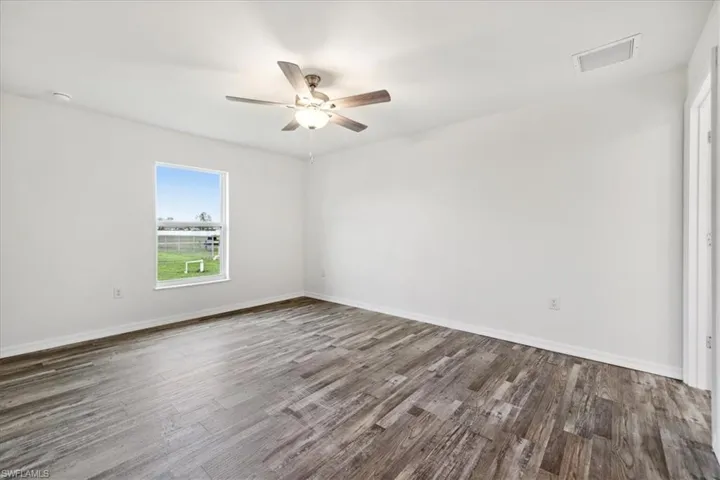 Spare room with ceiling fan and dark hardwood / wood-style floors