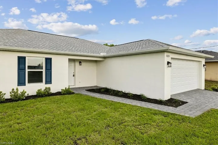 View of front of house featuring a garage and a front lawn