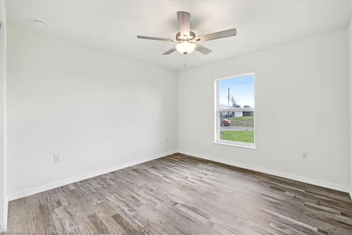 Unfurnished room featuring ceiling fan and hardwood / wood-style flooring