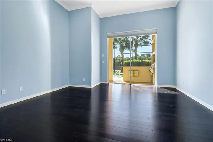 Primary Bedroom on the first floor.  Dark hardwood floors and crown molding.