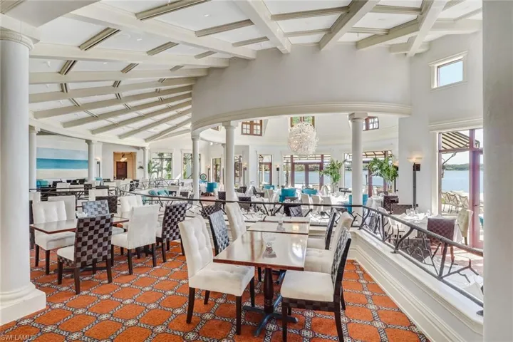 Beach Club Dining room featuring a water view, lofted ceiling with beams, and columns. A more formal dining experience.