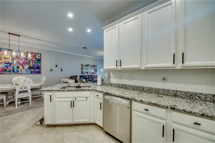 Kitchen with dishwasher, white cabinets, sink, tasteful backsplash, and kitchen peninsula