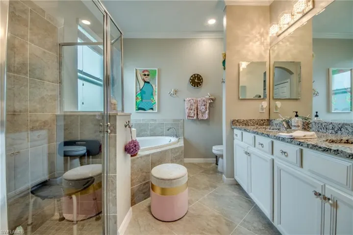 Full bathroom with vanity, separate shower and tub, toilet, and ornamental molding