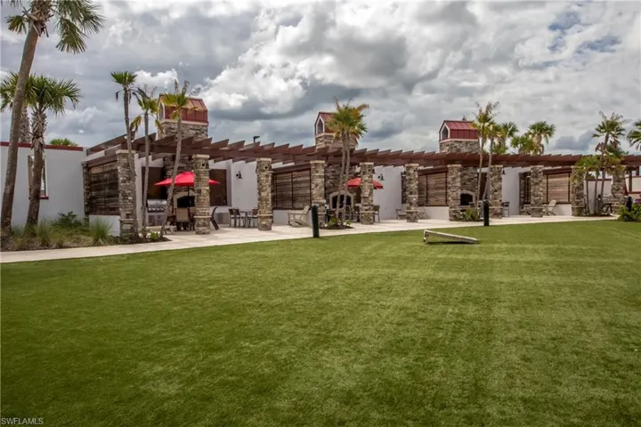 View of yard featuring an outdoor stone fireplace, a patio area, and a pergola