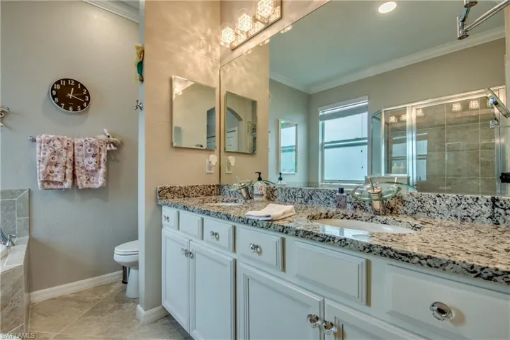 Full bathroom featuring tile patterned flooring, crown molding, toilet, vanity, and independent shower and bath