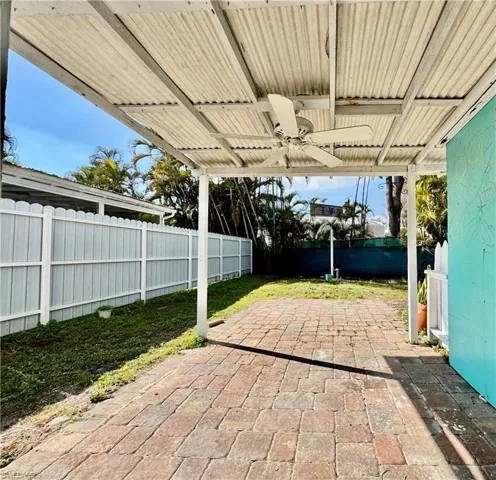 Fenced backyard featuring a ceiling fan and a patio