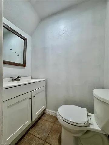 Half bath with vanity and vaulted ceiling