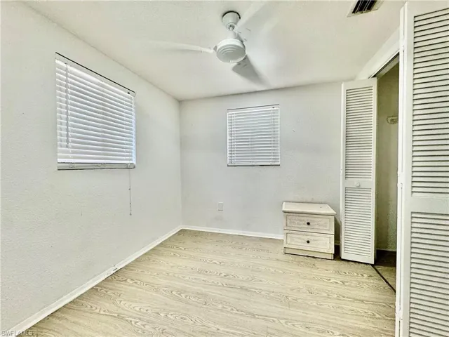 Unfurnished bedroom featuring light wood-type flooring, ceiling fan, a closet, a textured ceiling, and a textured wall