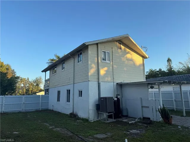 Back of house with a fenced backyard, a gate, and stucco siding