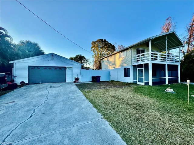 View of home's exterior featuring a yard, a sunroom, and a garage