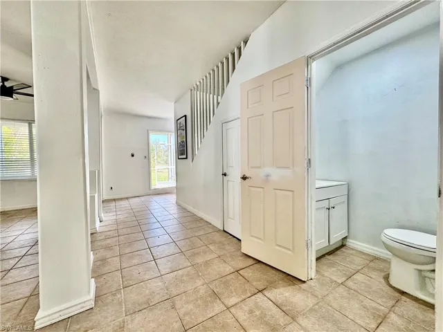 Hall featuring baseboards and light tile patterned floors