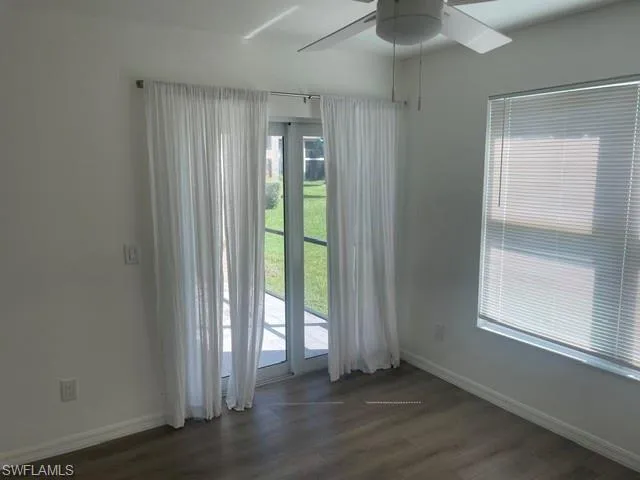 Room featuring wood-finish flooring, ceiling fan with integrated lighting, window blinds, and glass door access