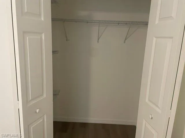 Closet featuring dual white panel doors, wood-finish flooring, and white wire shelving