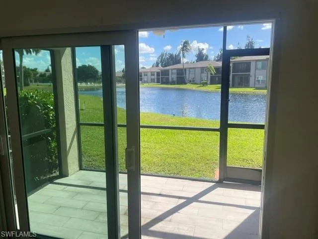 Screened-in Lanai with tile flooring, sliding glass door entry, and water frontage