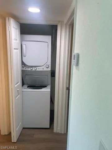 Stacked laundry appliance featuring a top-loading washer and front-loading dryer.