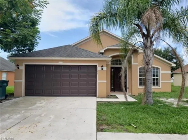 Single story home featuring stucco siding, concrete driveway, an attached garage, and a front yard