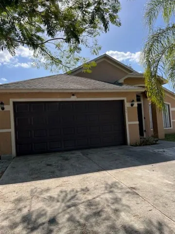 View of front facade featuring an attached garage, concrete driveway, and stucco siding