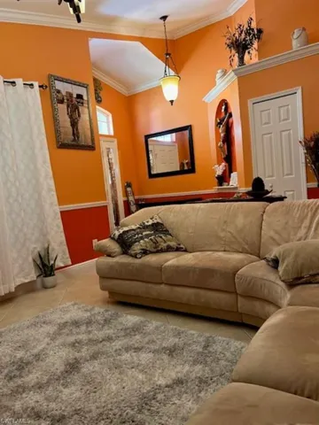Tiled living area with ornamental molding and baseboards