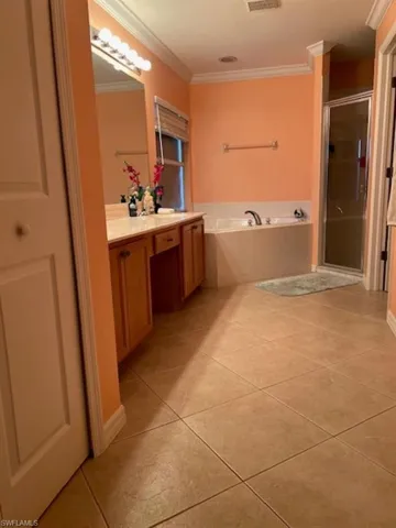 Full bathroom with a garden tub, tile patterned floors, a shower stall, crown molding, and vanity