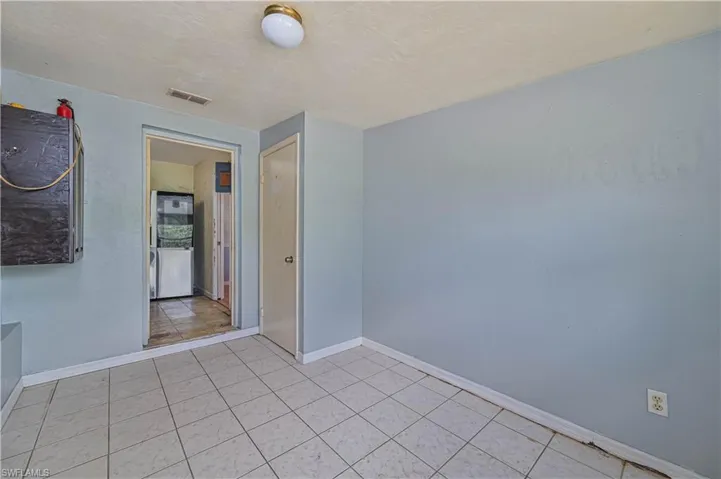 Tile flooring with light blue walls and a ceiling-mounted light fixture