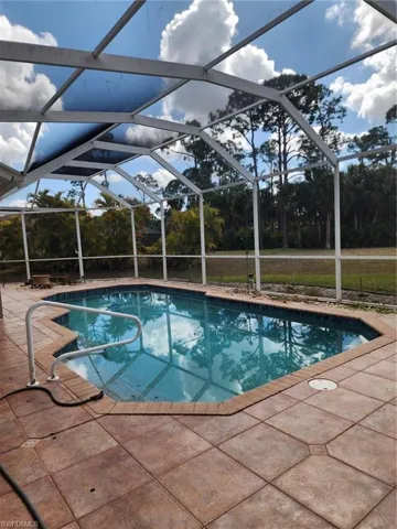 Outdoor pool with a sunroom, a lanai, and a patio area