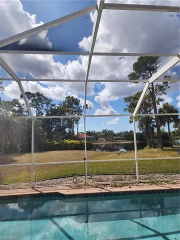 Outdoor pool featuring a yard, a lanai, and a water view