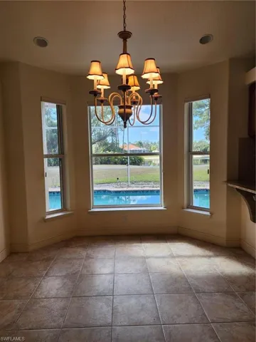 Unfurnished dining area with hanging lights and healthy amount of natural light