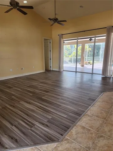 Empty room with ceiling fan, lofted ceiling, dark wood finished floors, and recessed lighting