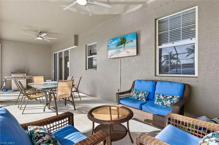 View of patio featuring an outdoor hangout area, grilling area, and ceiling fans